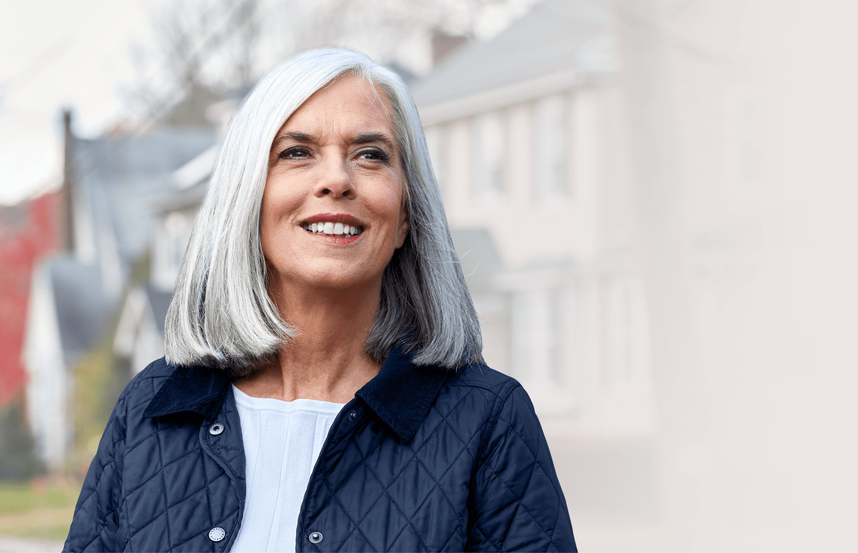 Header: Close-up of Assistant Speaker Katherine Clark smiling in a residential Massachusetts neighborhood.